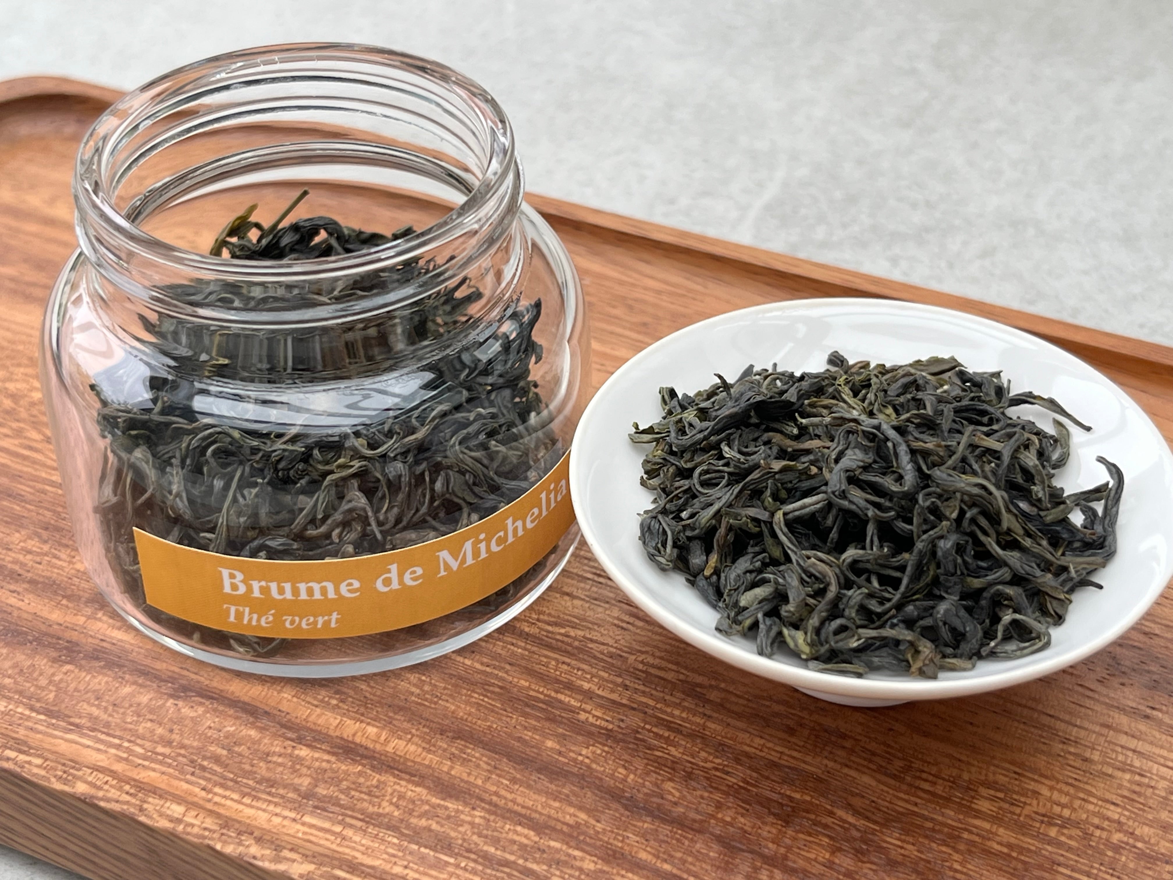 Brume de Michélia — Thé Vert 100g — Une fraîcheur intense, portée par un parfum de banane mûre aux accents floraux et vanillés.